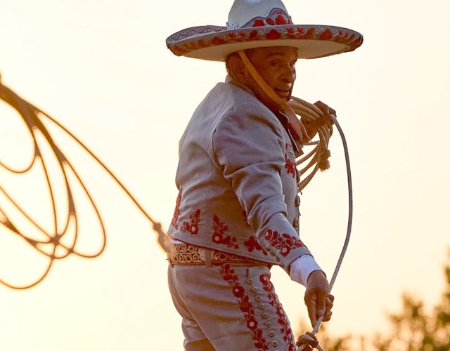 A man and boy silhouetted, swinging a rope and posing.